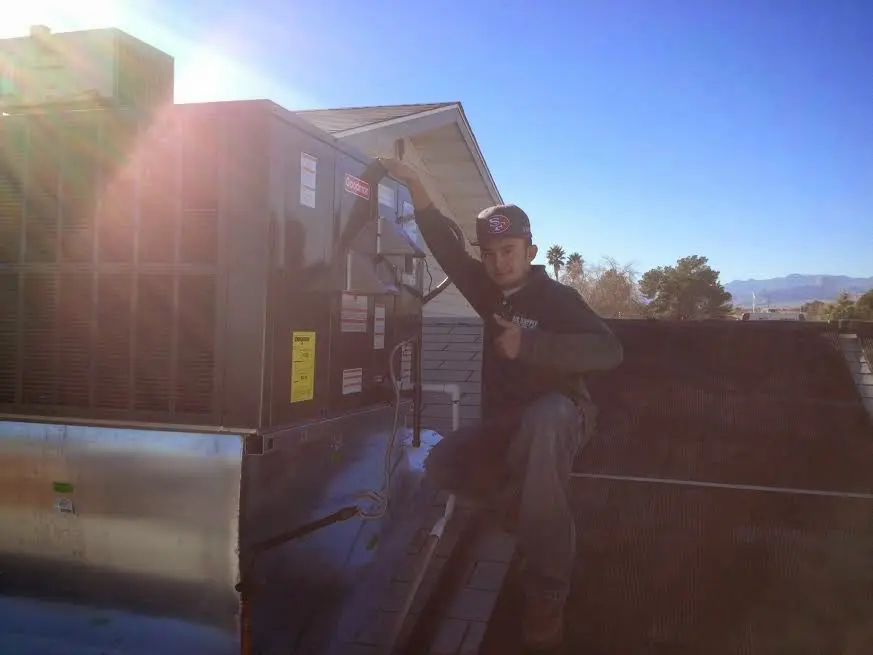 HVAC technician performing Air Duct Cleaning on a rooftop unit in Mishawaka